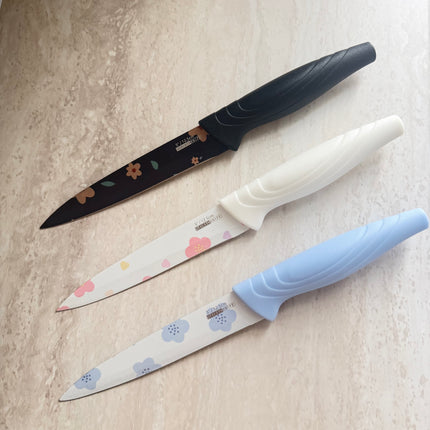 Three knives with floral patterns on the blade, placed on a light-colored surface.
